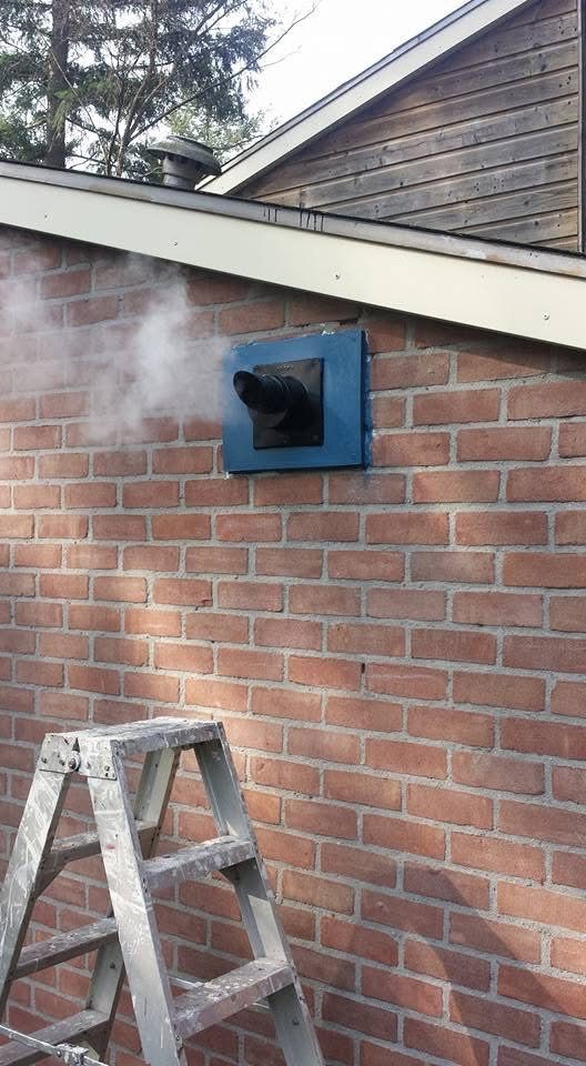 Montage van een nieuwe rookgasafvoer door de gevel